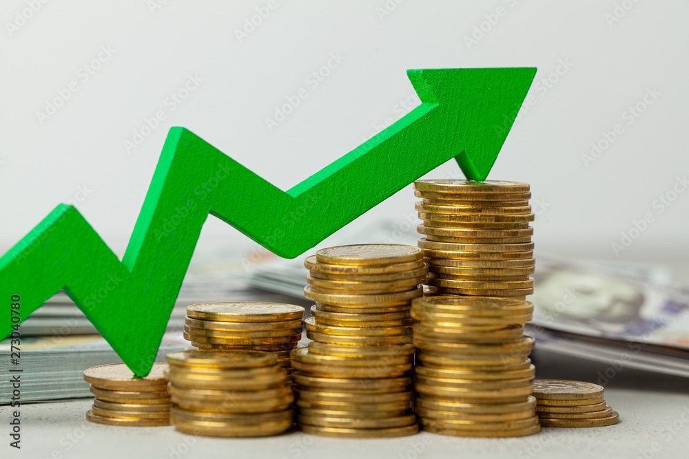Green arrow up graphics on a stack of coins. The concept of profit growth and indicators. Green arrow up graphics on a stack of coins. The concept of profit growth and indicators.