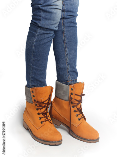Women's legs in orange shoes and blue jeans. Clothes in casual style.