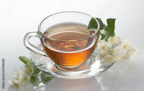 green tea with jasmine in a transparent glass thermomug on a white background