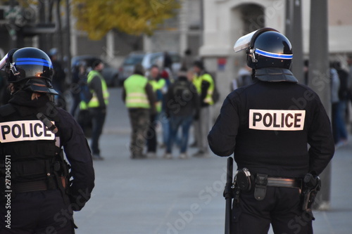 Helmeted police officers photographed from behind during a protest