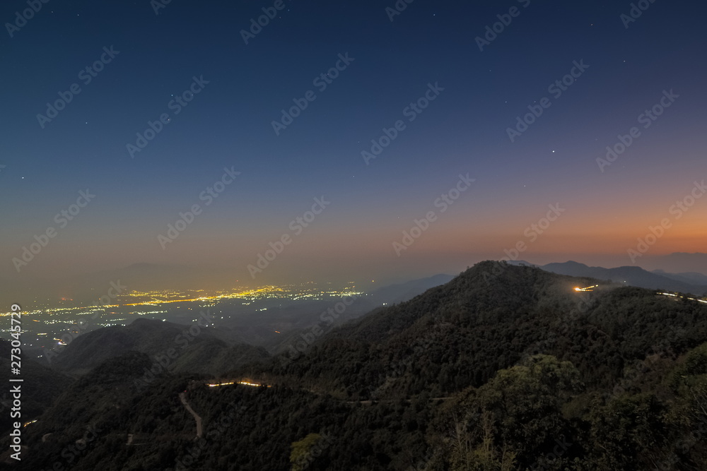 Fototapeta premium sunset at Doi Ang Khang, Mountain view evening of top hill around with soft fog and yellow sun light in the sky background, Monzone Camping Zone, Doi Angkhang, Chiang Mai, Thailand.