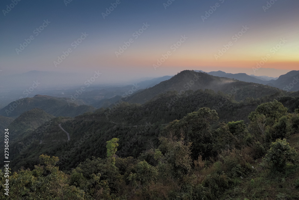 sunset at Doi Ang Khang, Mountain view evening of top hill around with soft fog and yellow sun light in the sky background, Monzone Camping Zone, Doi Angkhang, Chiang Mai, Thailand.