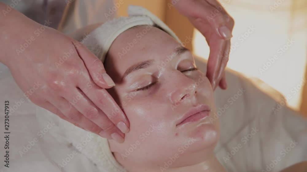 Professional beautician makes a complex massage to a young girl in the cosmetology office. Professional beautician makes a complex massage to a young girl in the cosmetology office.