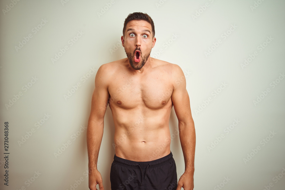 Young handsome shirtless man over isolated background afraid and shocked with surprise expression, fear and excited face.