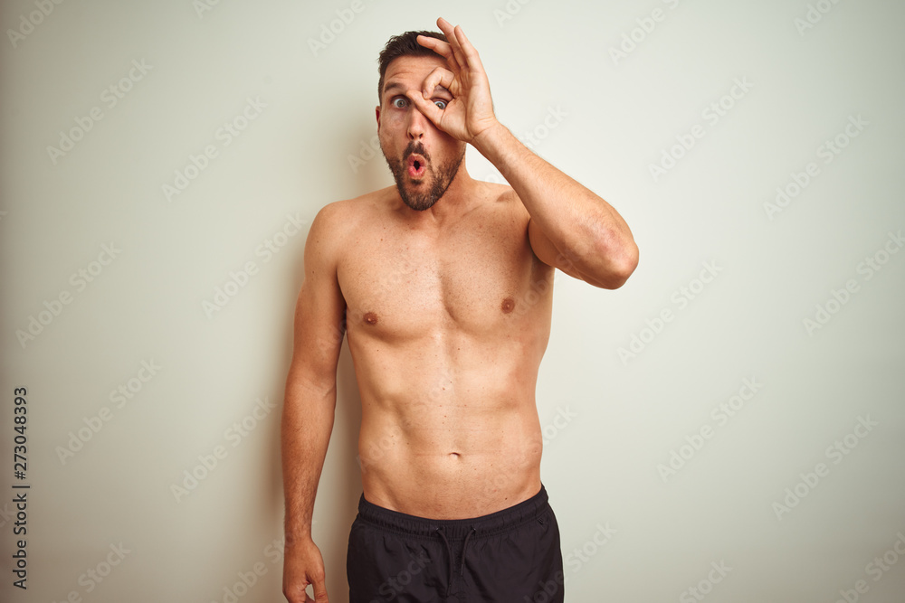 Young handsome shirtless man over isolated background doing ok gesture shocked with surprised face, eye looking through fingers. Unbelieving expression. Young handsome shirtless man over isolated background doing ok gesture shocked with surprised face, eye looking through fingers. Unbelieving expression.