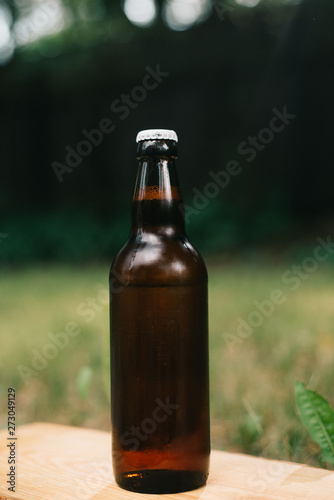 Holding cold beer at garden in hot summer evening