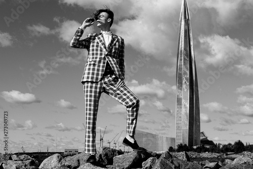 handsome fashion male model dressed in elegant suit posing outdooe. Long haired Metrosexual. Black and white picture. photo