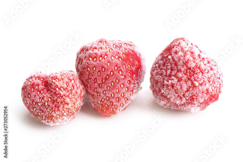 Three frozen strawberries, covered with hoarfrost on a white background...