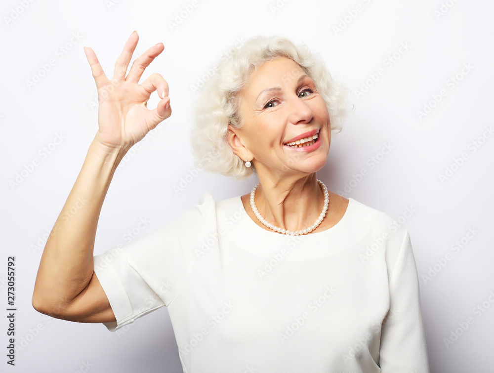 Lifestyle, emotion and people concept: Elderly happy woman giving a thumb up and looking at the camera Lifestyle, emotion and people concept: Elderly happy woman giving a thumb up and looking at the camera