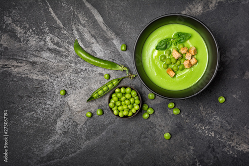 Soup of green peas with basil leaves and croutons