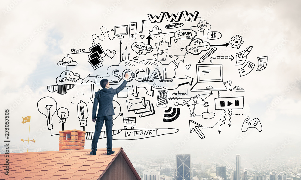 Rear view of businessman on house roof drawing his new business Rear view of businessman on house roof drawing his new business