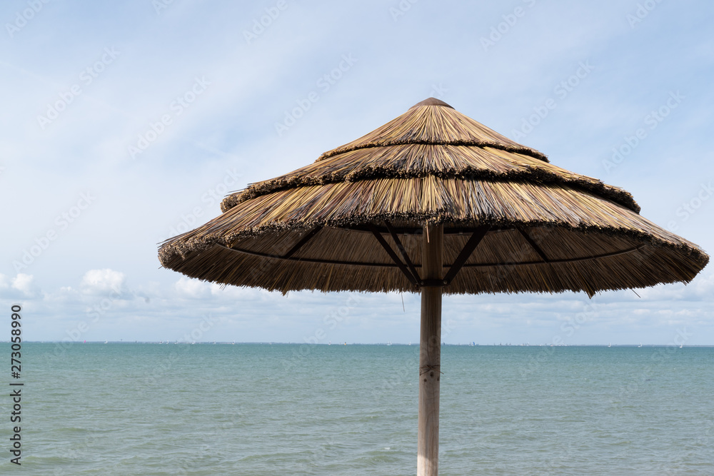 beach umbrella at tropical beach over blue sky