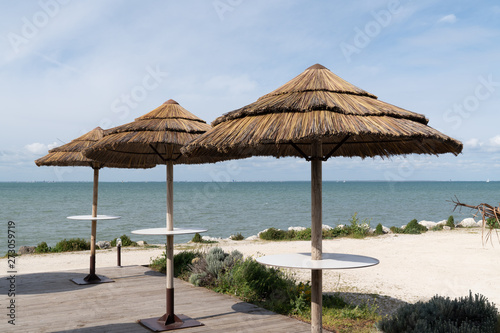 beach cafe with straw parasols © OceanProd