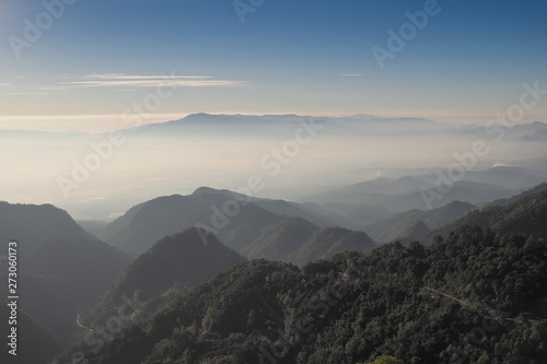 Mountain view misty morning of top hill around with sea of mist and blue sky background  sunrise at Doi Ang Khang  Monzone view point  Chiang Mai  Thailand.