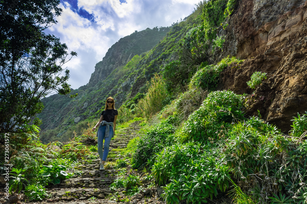 Beautiful woman walking on mountain coastline of Madeira island