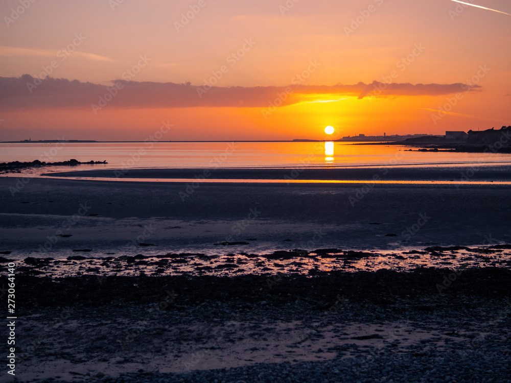 Sunset over Galway bay, Ireland, Rich orange warm color. Ballyloughane beach. Atlantic ocean,