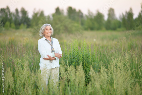 Fotografie Portrait of happy senior beautiful woman posing in spring park