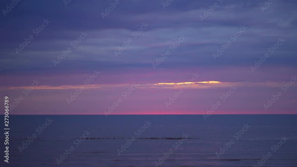 Amazing dark scenic vivid crimson rare red sunset with violet and magenta colors at the Baltic Sea with small sun at the horizon Amazing dark scenic vivid crimson rare red sunset with violet and magenta colors at the Baltic Sea with small sun at the horizon