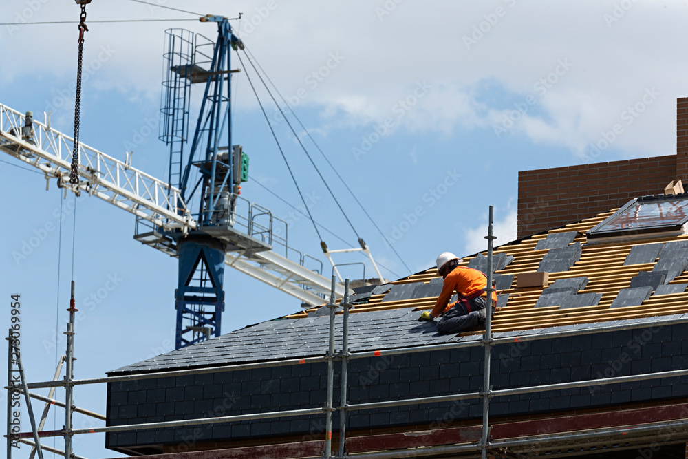 Obrero trabajando en la construcción del tejado de un edificio.