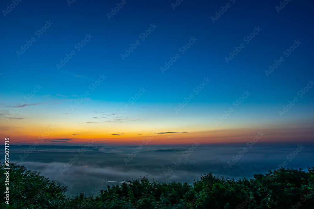 Sunrise on a foggy summer morning over the village