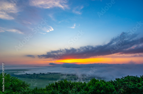 Sunrise on a foggy summer morning over the village