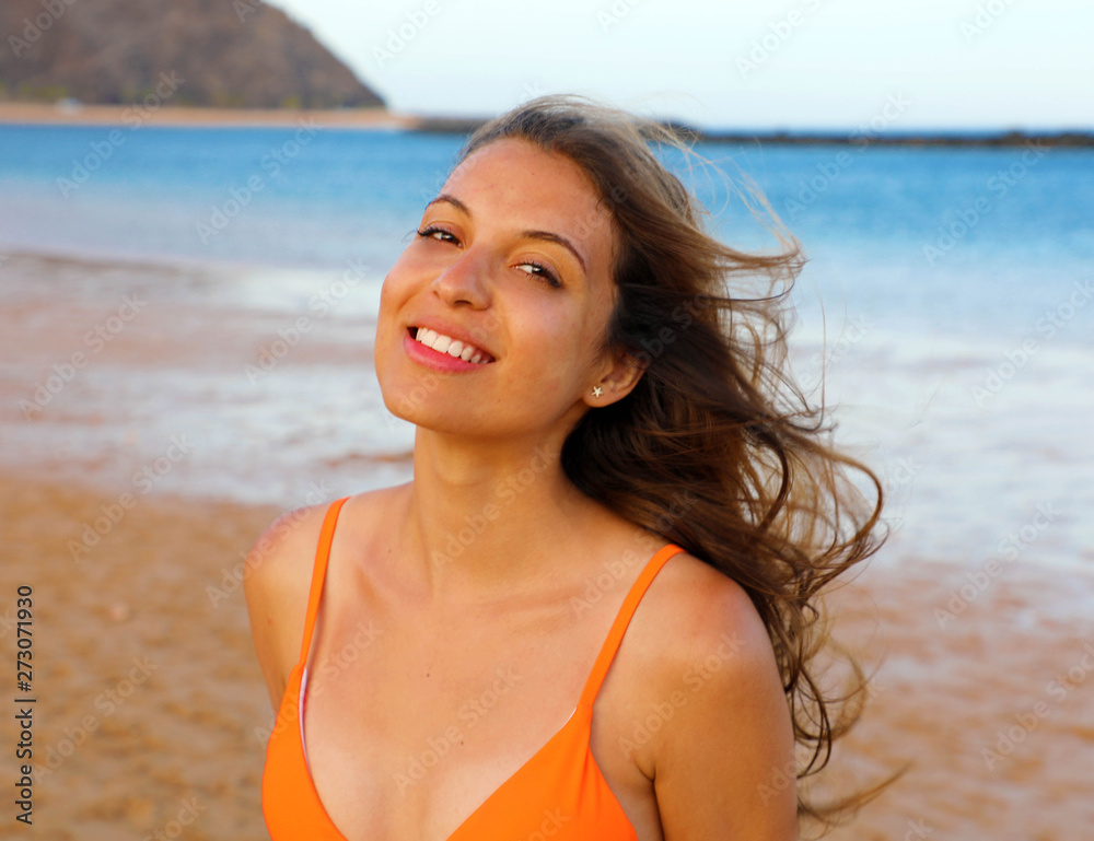Happy woman on the beach. Portrait of beautiful girl with wind fluttering hair. Summer portrait on the beach at sunset. Young pretty smiling woman outdoors portrait. Happy woman on the beach. Portrait of beautiful girl with wind fluttering hair. Summer portrait on the beach at sunset. Young pretty smiling woman outdoors portrait.