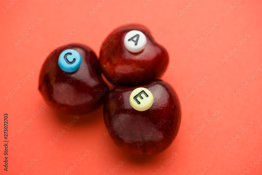 Letters indicating the vitamins contained in cherries on three berries are stacked together. Letters indicating the vitamins contained in cherries on three berries are stacked together.