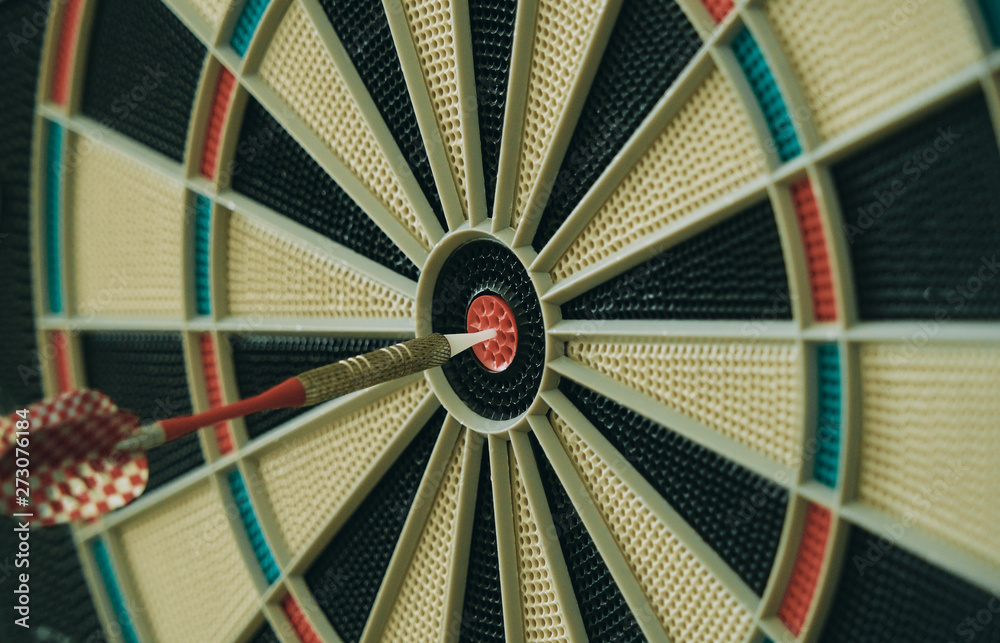 Obraz premium Closeup of dart board with dart in the bulls eyes.
