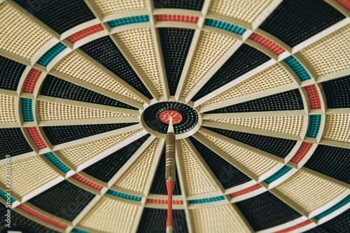 Closeup of dart board with dart in the bulls eyes.