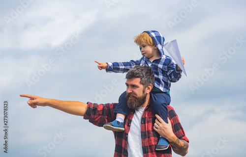 Father and son playing together. Cute boy with dad playing outdoor. Childhood. Daddy and child son. Happy kid playing with paper airplane. Carefree.