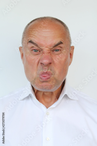 bald old man in white shirt showing tongue, close-up