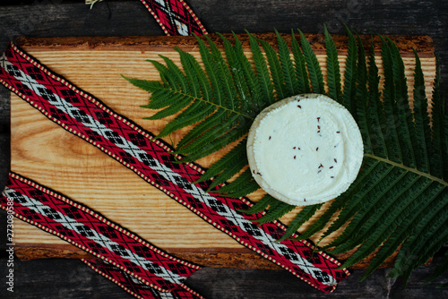 Latvian cheese with fern and national belt