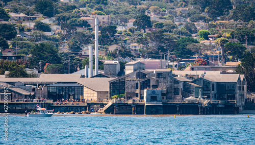 Canvas-taulu The Monterey Bay Aquarium, a popular tourist destination on the Central Coast, is viewed from a passing boat