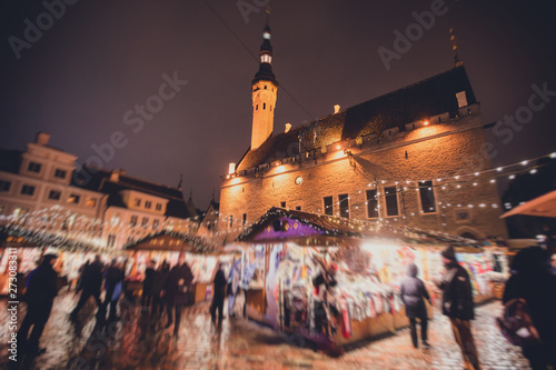 View of Tallinn Old Town, traditional european Christmas Fair Market at Old Town Hall Square, with Christmas tree and fair kiosk with loads of shining decoration, Estonia