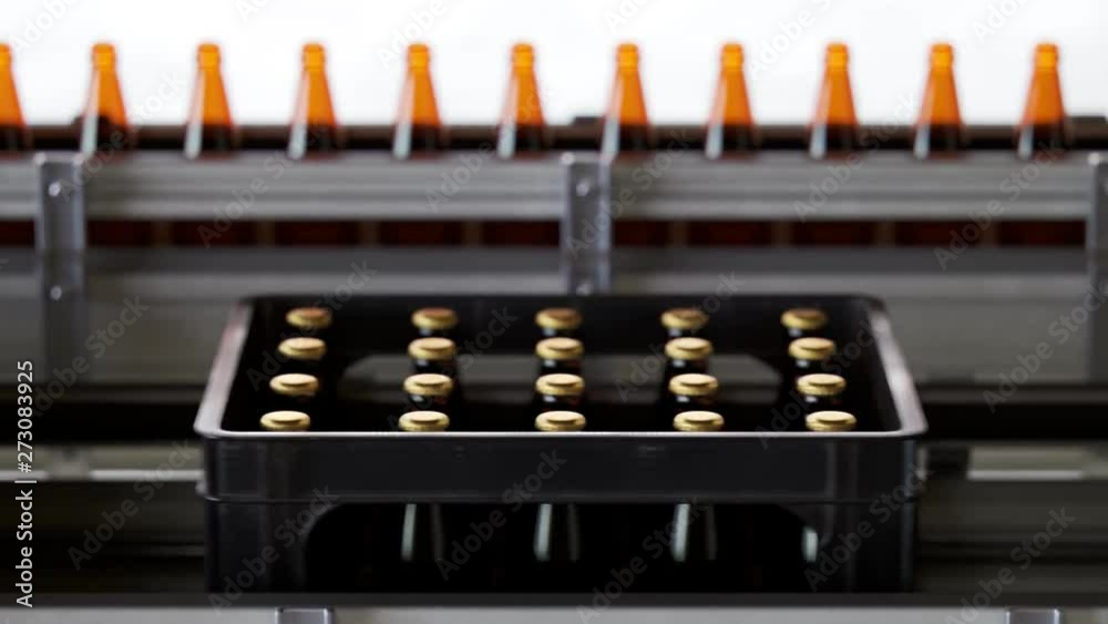Plastic crates full of freshly brewed beer bottles on a factory pipeline. 4KHD Plastic crates full of freshly brewed beer bottles on a factory pipeline. 4KHD