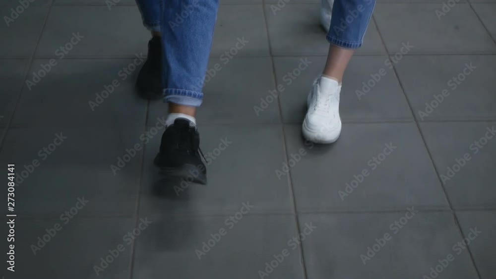 slow motion,Legs beyond recognition. young couple walking on the sidewalk. happy couple in stylish clothes.feet of a couple in love walking through the mall slow motion,Legs beyond recognition. young couple walking on the sidewalk. happy couple in stylish clothes.feet of a couple in love walking through the mall
