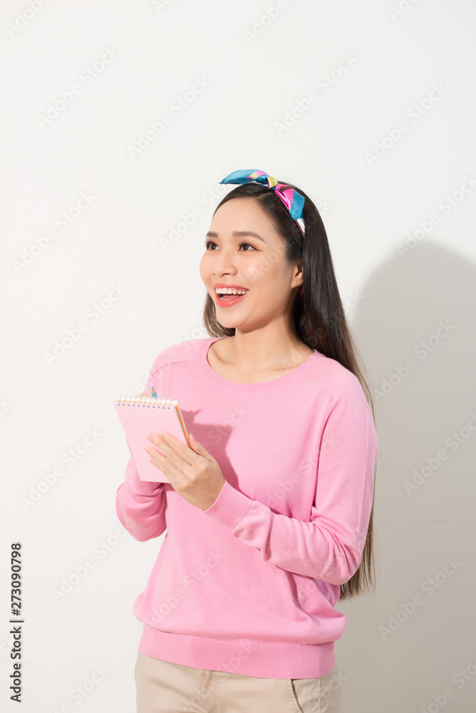 Portrait with copy space empty place of pretty, trendy, charming, nice, sexy, cute woman isolated on white background organizing her day, having notebook and pencil in hands