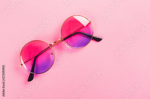 Round summer duotone sunglasses on pink background.