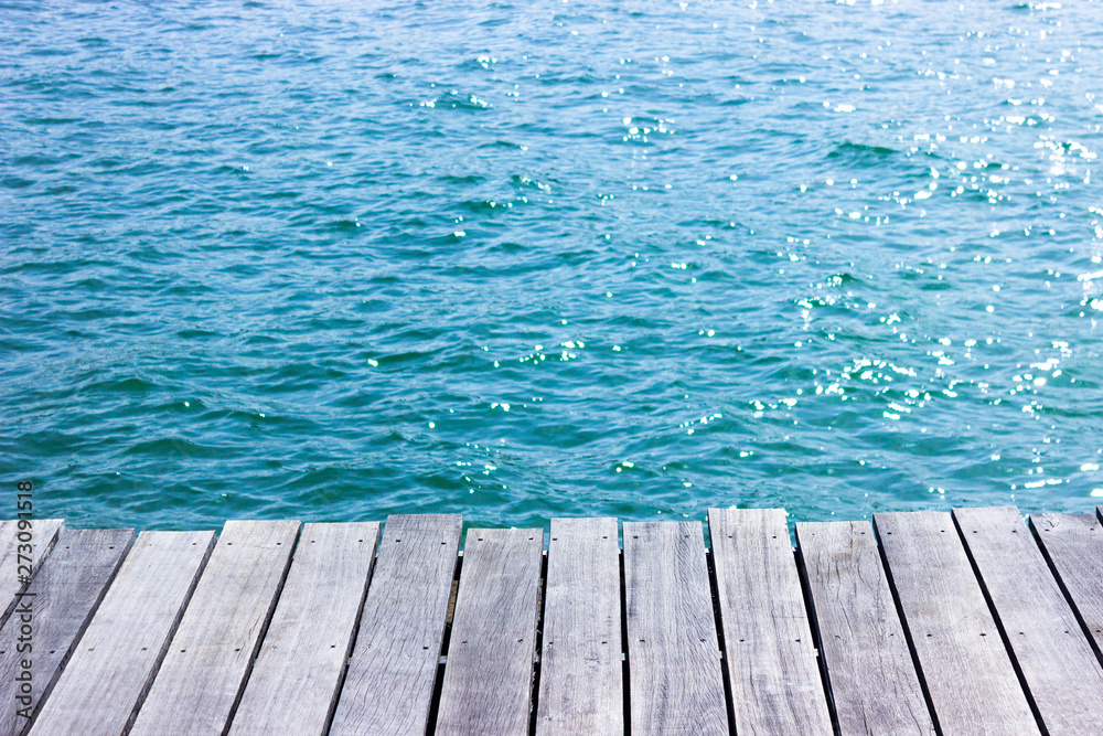 wooden table top with blue sea background.