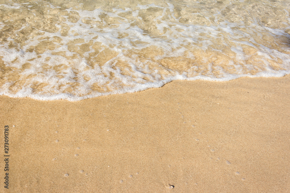 Soft waves with foam of ocean on the sandy beach background Soft waves with foam of ocean on the sandy beach background