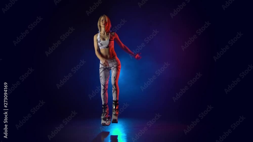 Lovely female in sports suit jumping in kangoo jumps shoes. Lovely female in sports suit jumping in kangoo jumps shoes.