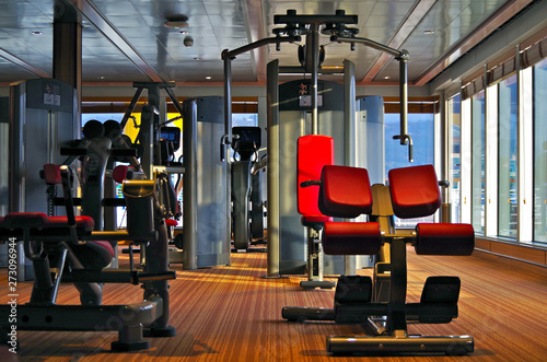 Moderne Fitnessgeräte mit roter Lederbespannung in Sportstudio auf Kreuzfahrtschiff photo