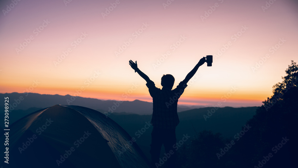 freedom time of hiker man holding coffee cup near camping tent on mountains at sunset background. travel concept.