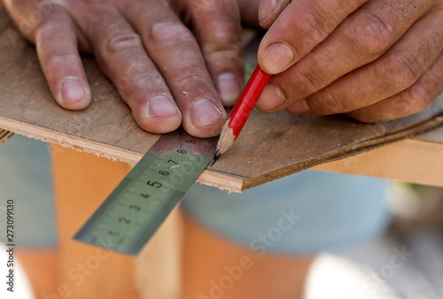  carpenter draws a pencil on a wooden surface