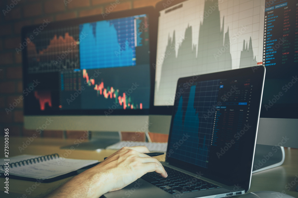 Investors are using laptops entering investment websites stocks market and analyzing performance data. Investors are using laptops entering investment websites stocks market and analyzing performance data.