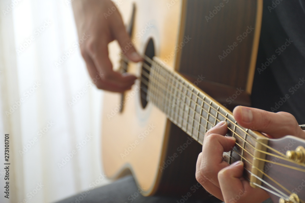 Fototapeta premium Midsection of the young man playing acoustic guitar