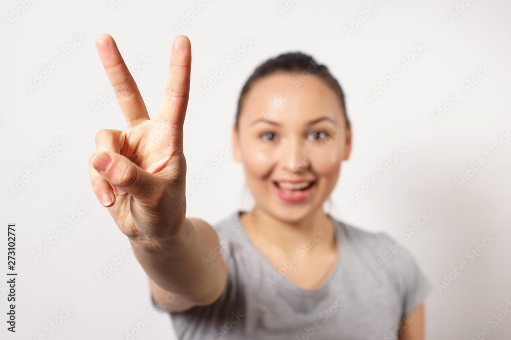 Beautiful young happy smiling girl showing victopy sing with her hand. Peace concept. Sign of gestures. It is ok Beautiful young happy smiling girl showing victopy sing with her hand. Peace concept. Sign of gestures. It is ok