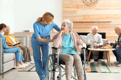 Fototapeta Nurses assisting elderly people at retirement home