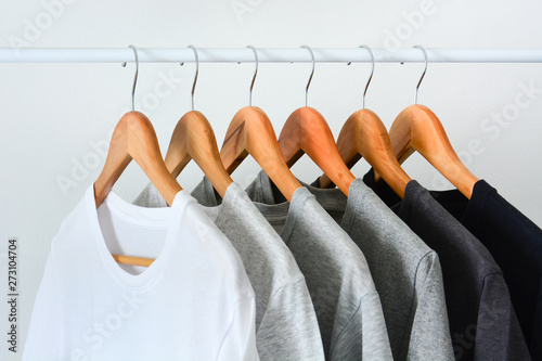 close up collection of black, gray and white color (monochrome) hanging on wooden clothes hanger in closet or clothing rack over white background photo