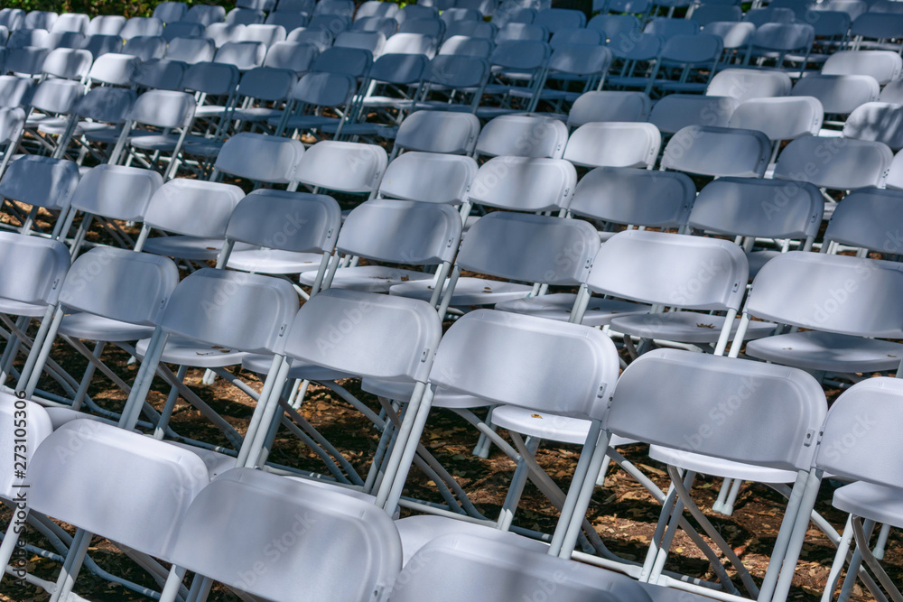 Naklejka premium White plastic chairs set up an outdoor in row before ceremony, event or party